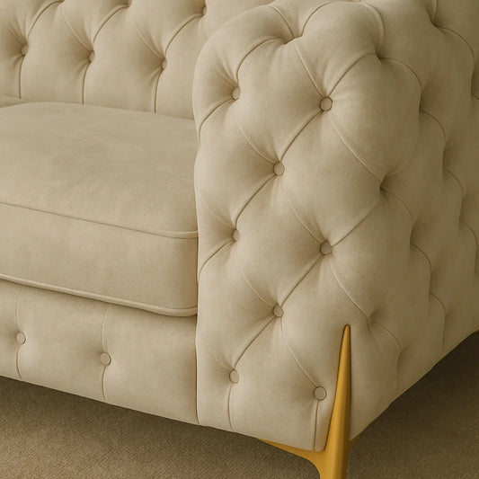 Beige tufted sofa with gold legs on a neutral background